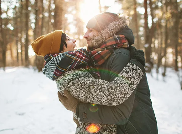 Couple embracing in snowy woods