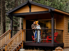 A couple on the porch at The Explorer Cabins at Tenaya Lodge