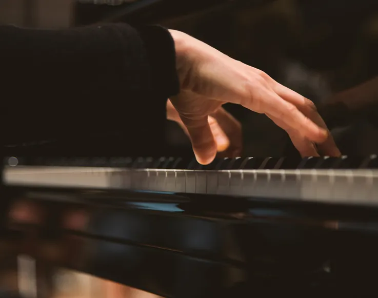 Upcoming Events 6 Hands playing a piano