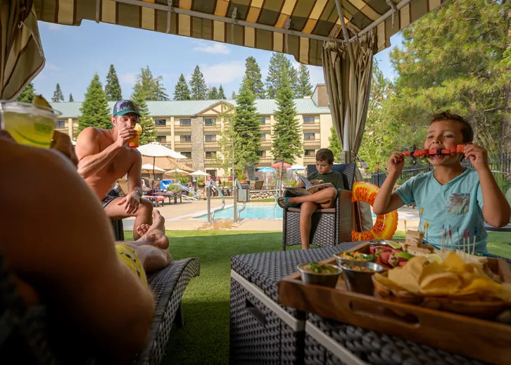 A family enjoying outdoor drinks and food at Tenaya at Yosemite