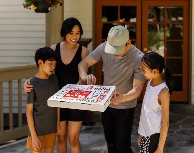 A family getting a pizza from Timberloft Pizzeria at Tenaya at Yosemite