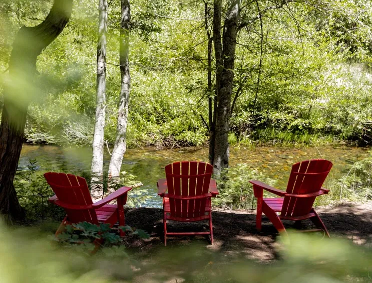 Adirondack chairs next to a gentle river near Yosemite National Park