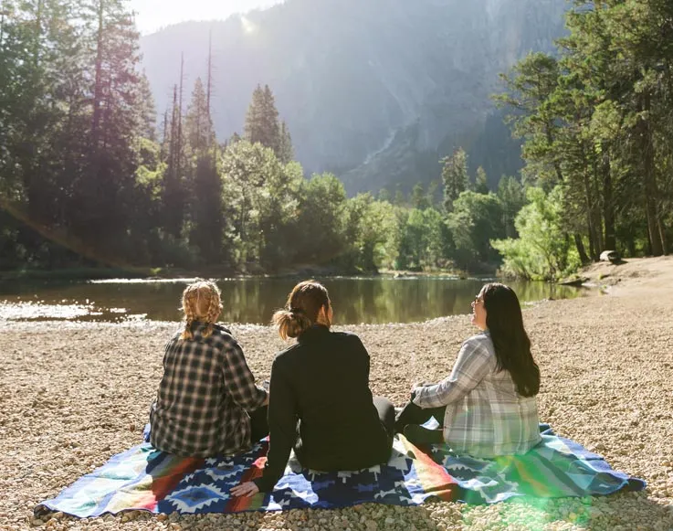 Specials / Packages 6 A group of Yosemite visitors relaxing next to a body of water