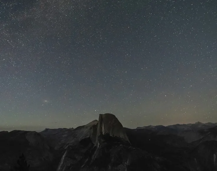 Half Dome under a starry night sky as seen from Glacier Point in Yosemite