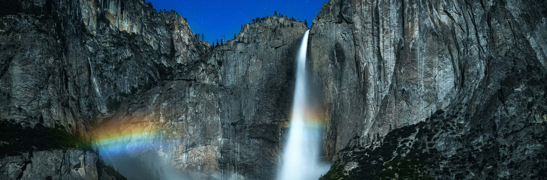 Yosemite Falls at night with a moonbow