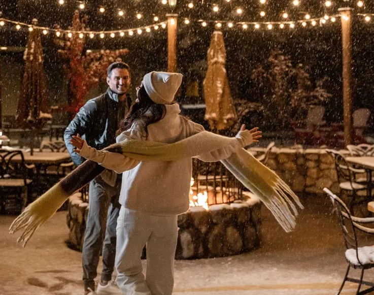 Two guests dancing outdoors in the snow at Tenaya at Yosemite