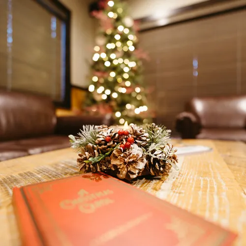 Winter Wonderland Cabins 6 A book and centerpiece on a coffee table in a holiday cabin at Tenaya at Yosemite with a Christmas tree in the background