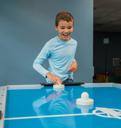 A boy playing air hockey at Tenaya at Yosemite
