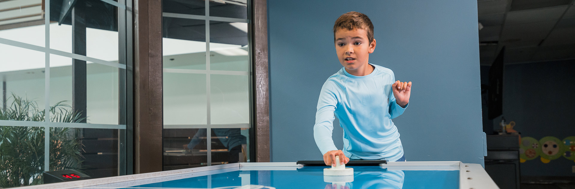 Family Game Room 1 A Tenaya guest playing air hockey in the Family Game Room