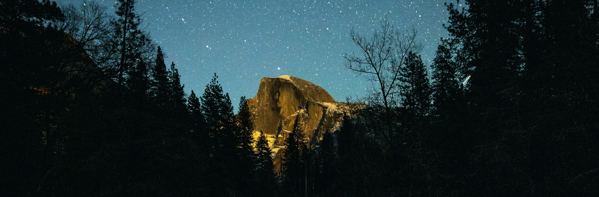 A starry night sky over Half Dome in Yosemite Valley