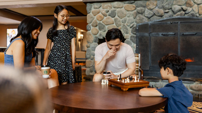 A family playing Chess at Tenaya at Yosemite