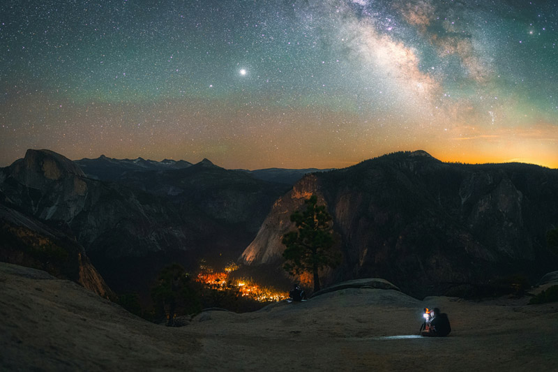 A view of Yosemite Valley at night with a starry sky above