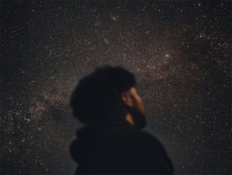 A Tenaya visitor looking up at a starry night sky