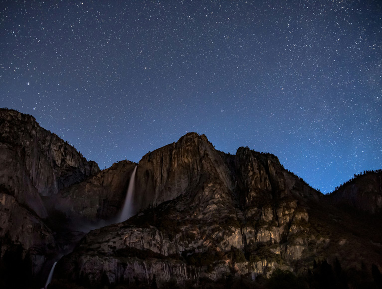 A starry night sky over Yosemite Falls