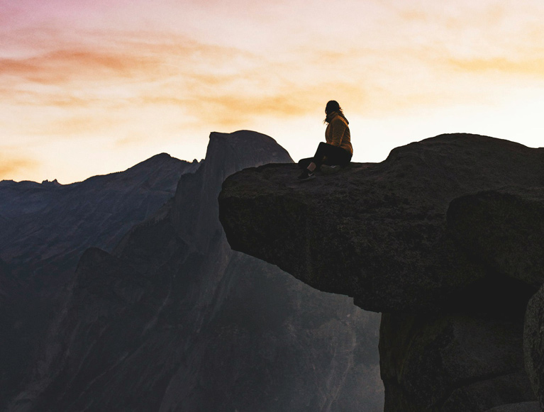 A hiker at Yosemite's Glacier Point at sunrise