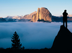 A Yosemite visitor enjoying a view of Half Dome over a sea of clouds