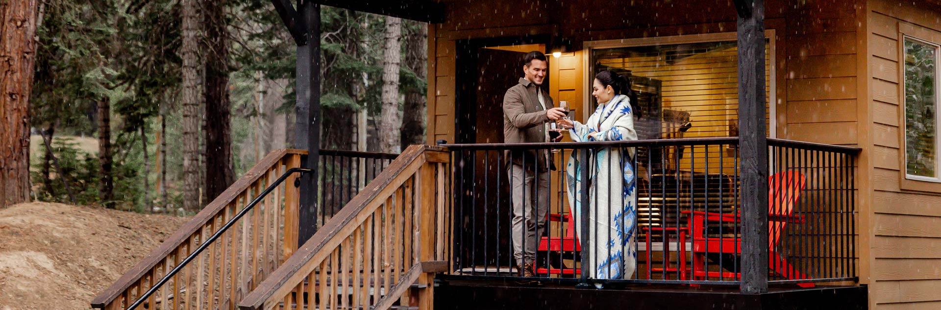 A couple relaxing on the porch of their Explorer Cabin at Yosemite