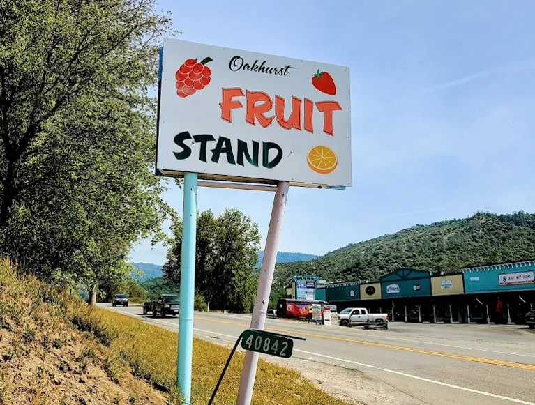 A fruit stand road sign in Oakhurst, CA