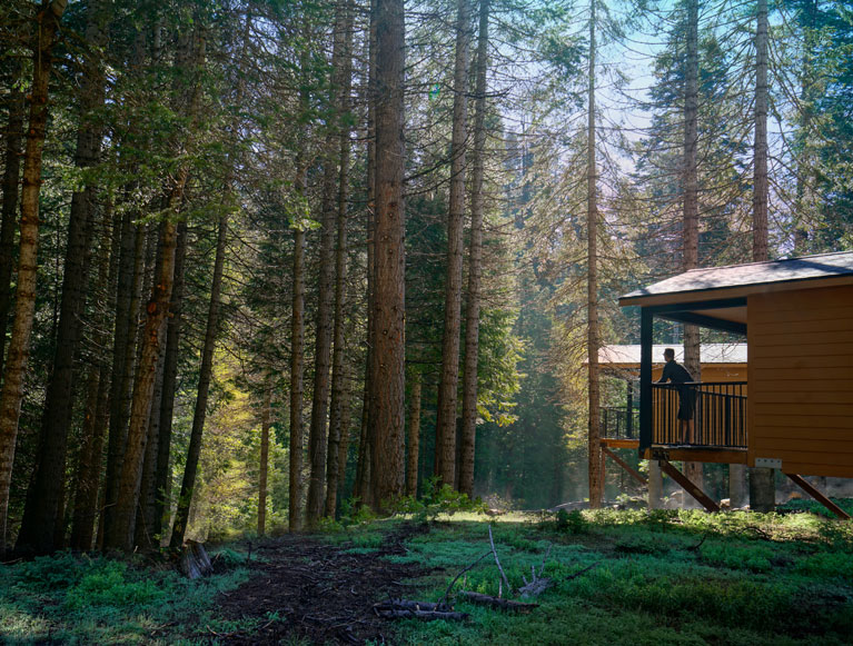 A guest on a cabin porch at Tenaya at Yosemite