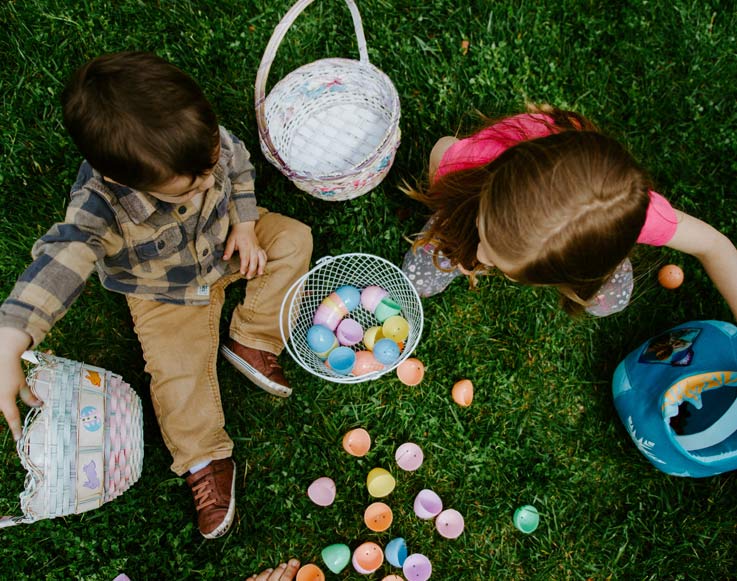 Two children gathering Easter Eggs in baskets