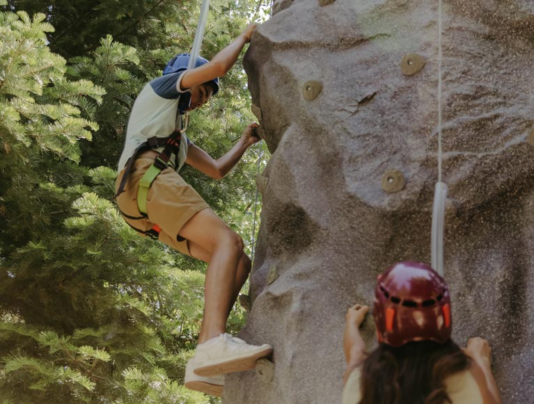 Two kids exploring the climbing wall at Tenaya at Yosemite