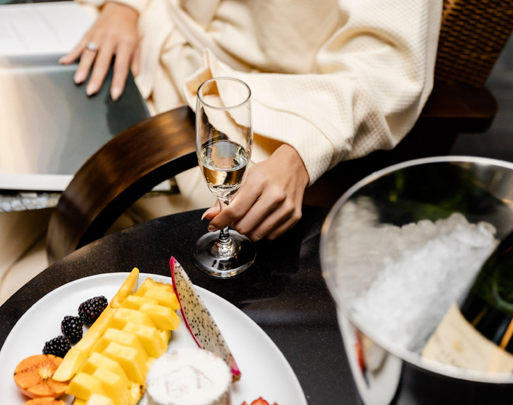 A guest enjoying a fruit platter and a glass of champagne at Tenaya at Yosemite